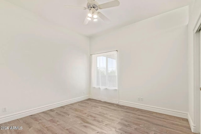 spare room with baseboards, light wood-style flooring, and a ceiling fan