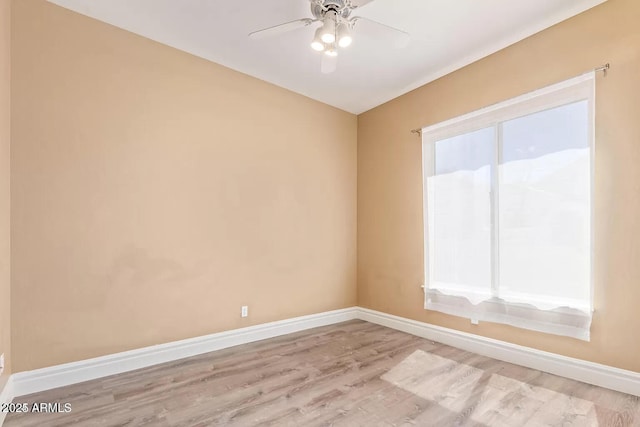 unfurnished room featuring baseboards, light wood-type flooring, and a ceiling fan