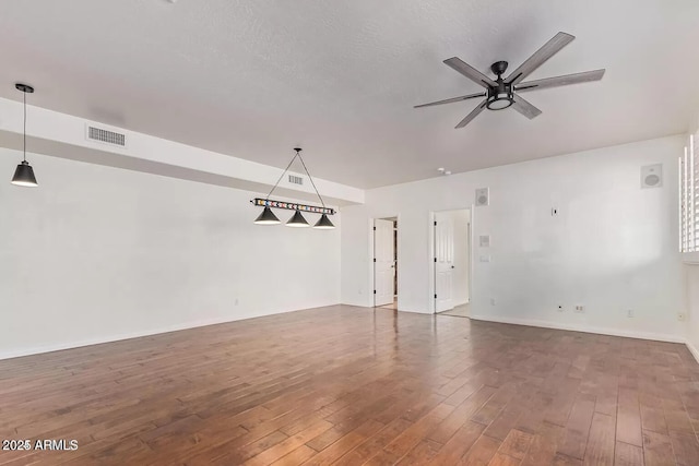 unfurnished room featuring baseboards, visible vents, ceiling fan, and hardwood / wood-style floors