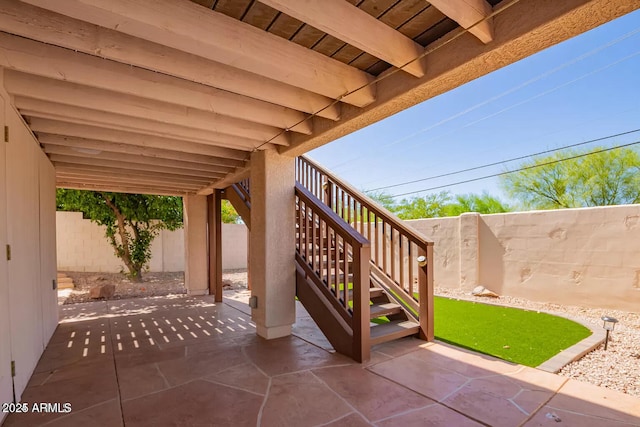 view of patio with a fenced backyard and stairway