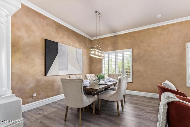 dining area featuring wood finished floors, ornamental molding, baseboards, and ornate columns