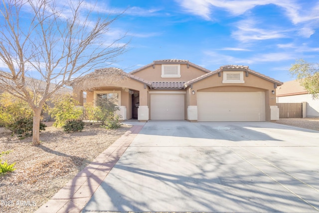 mediterranean / spanish-style home with concrete driveway, an attached garage, a tiled roof, and stucco siding