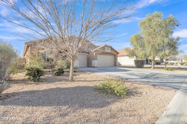 view of property hidden behind natural elements with driveway, an attached garage, and stucco siding