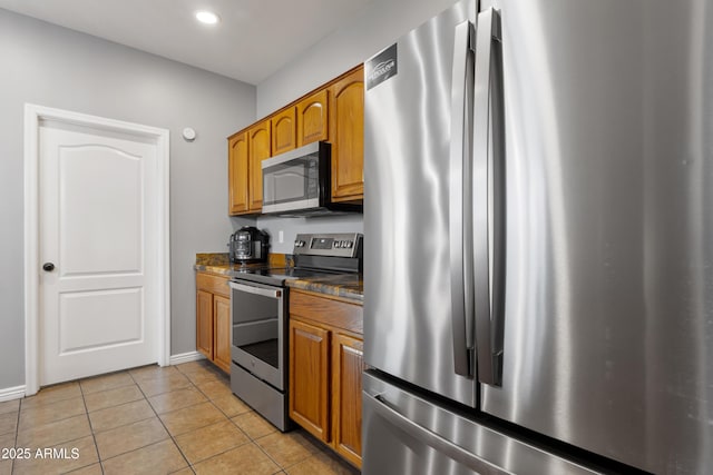 7305 W Darrel Rd, Laveen, AZ 85339 - kitchen featuring stainless steel appliances, light tile patterned floors, dark countertops, brown cabinets, and baseboards
