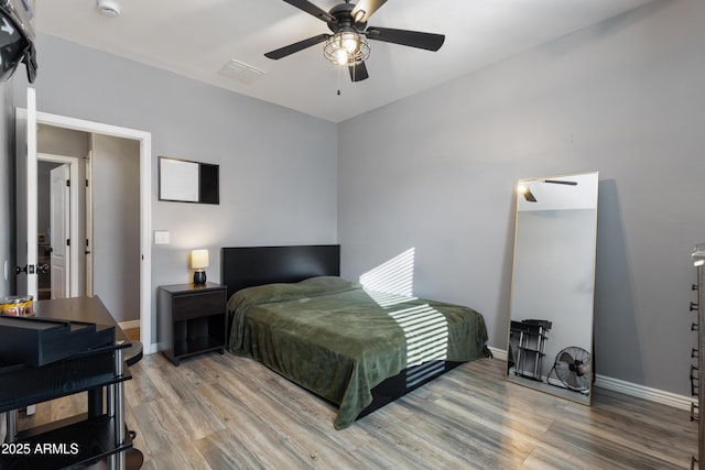 7305 W Darrel Rd, Laveen, AZ 85339 - bedroom with wood finished floors, baseboards, and a ceiling fan