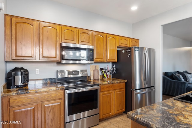 7305 W Darrel Rd, Laveen, AZ 85339 - kitchen featuring stainless steel appliances, brown cabinetry, light tile patterned floors, recessed lighting, and dark stone counters