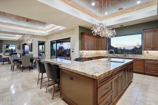 kitchen with a chandelier, a spacious island, decorative light fixtures, and a tray ceiling