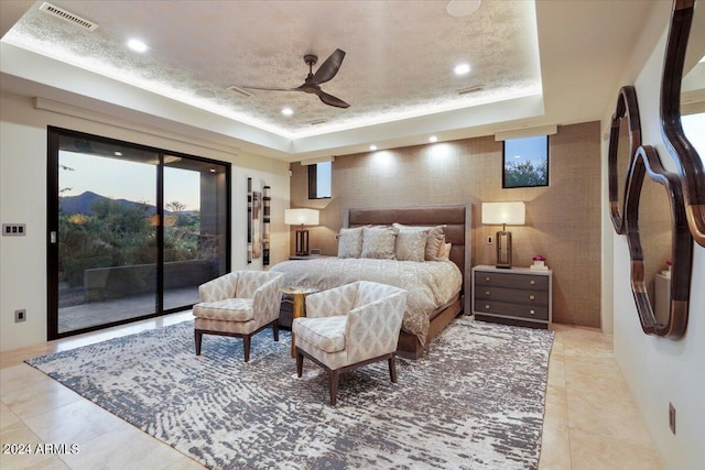 tiled bedroom with refrigerator, access to outside, ceiling fan, and a tray ceiling