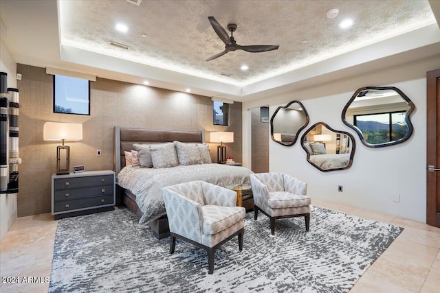 tiled bedroom with a raised ceiling and ceiling fan