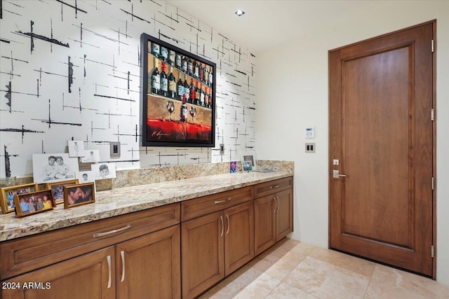 bar featuring light stone countertops and light tile patterned floors