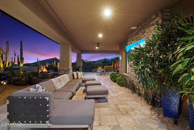 patio terrace at dusk featuring an outdoor living space with a fire pit