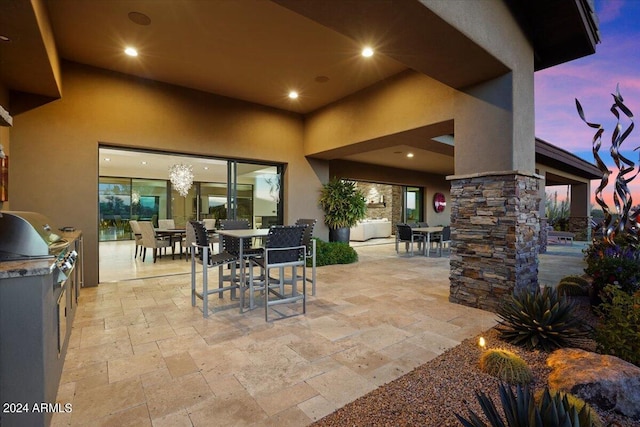 patio terrace at dusk with area for grilling and exterior kitchen