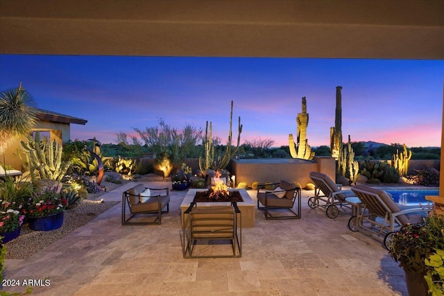 patio terrace at dusk with an outdoor living space with a fire pit