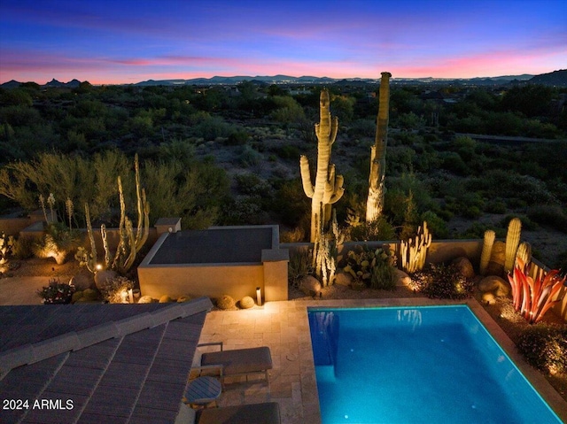 pool at dusk with a patio