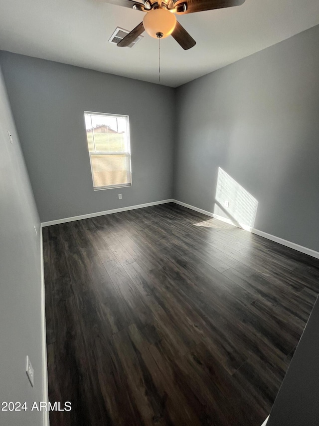 unfurnished room with ceiling fan and dark hardwood / wood-style flooring