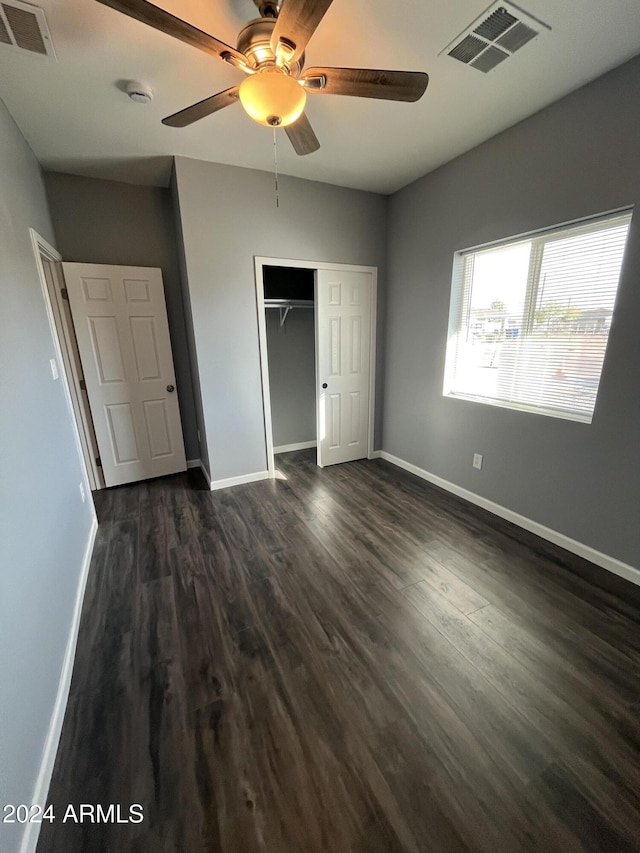 unfurnished bedroom featuring a closet, dark hardwood / wood-style floors, and ceiling fan