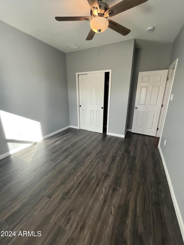 unfurnished bedroom featuring a closet, ceiling fan, and dark wood-type flooring