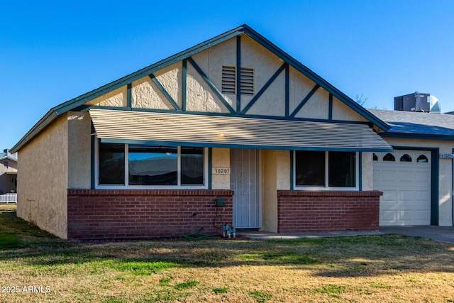 english style home with a front lawn, a garage, and central AC