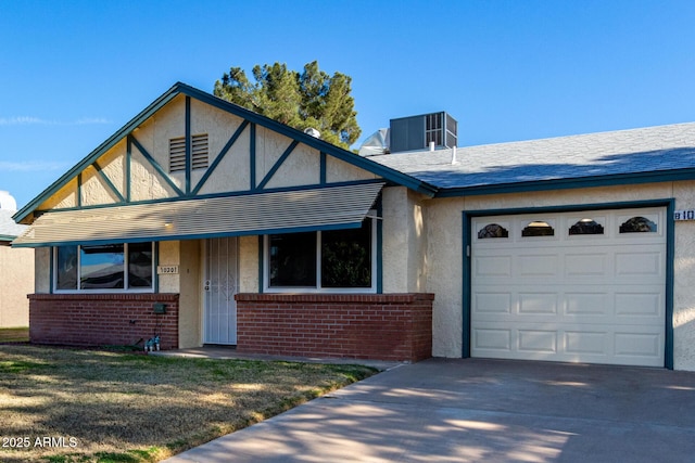 view of front of home featuring central AC unit, a front yard, and a garage