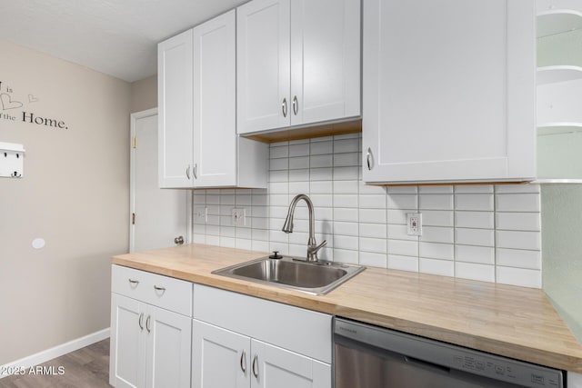 kitchen with stainless steel dishwasher, decorative backsplash, sink, white cabinetry, and hardwood / wood-style flooring