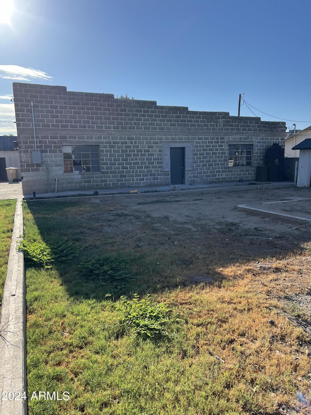 back of house featuring a lawn