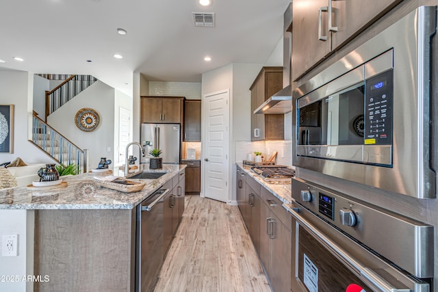 17831 W Mission Ln, Waddell, AZ 85355 - kitchen with visible vents, appliances with stainless steel finishes, light stone countertops, recessed lighting, and light wood-style flooring