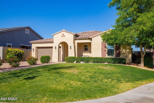 mediterranean / spanish-style home with a front lawn and a garage