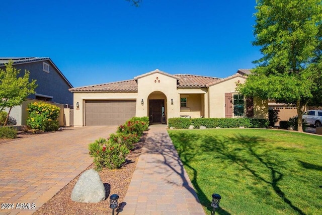 mediterranean / spanish house featuring a front yard and a garage