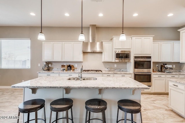 kitchen featuring appliances with stainless steel finishes, sink, a kitchen island with sink, and pendant lighting