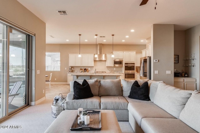 carpeted living room with sink and ceiling fan