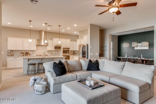 living room featuring ceiling fan and sink