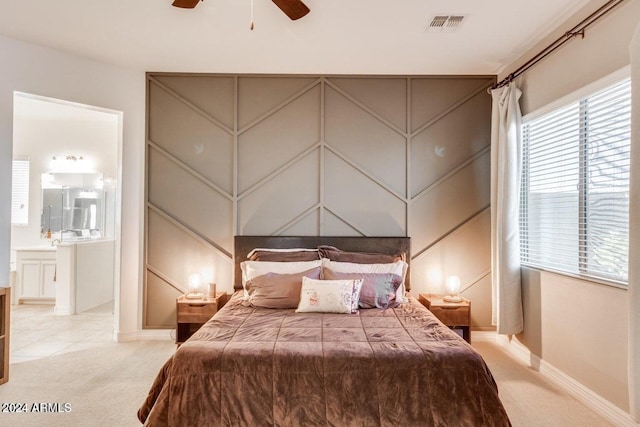 carpeted bedroom featuring ensuite bath and ceiling fan