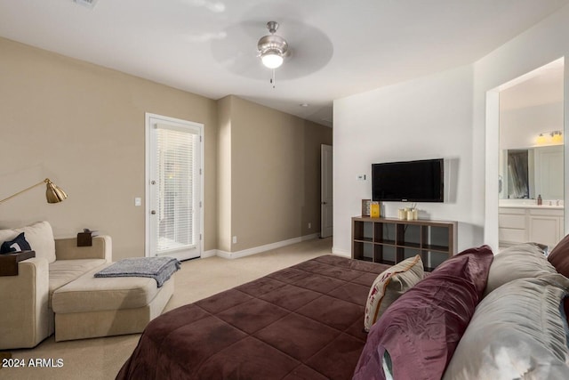 bedroom with ceiling fan, ensuite bathroom, and light colored carpet