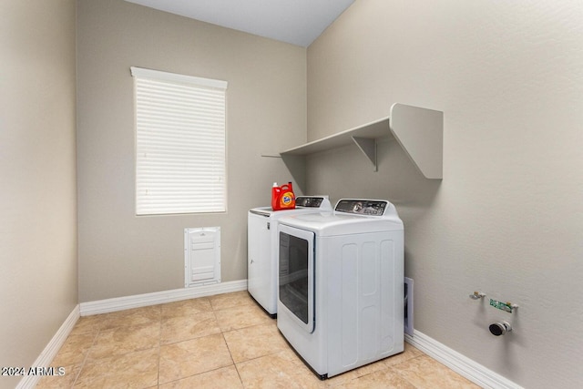 laundry room featuring light tile patterned flooring and washing machine and dryer