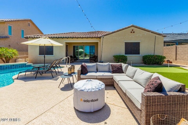 back of house with a fenced in pool, outdoor lounge area, and a patio