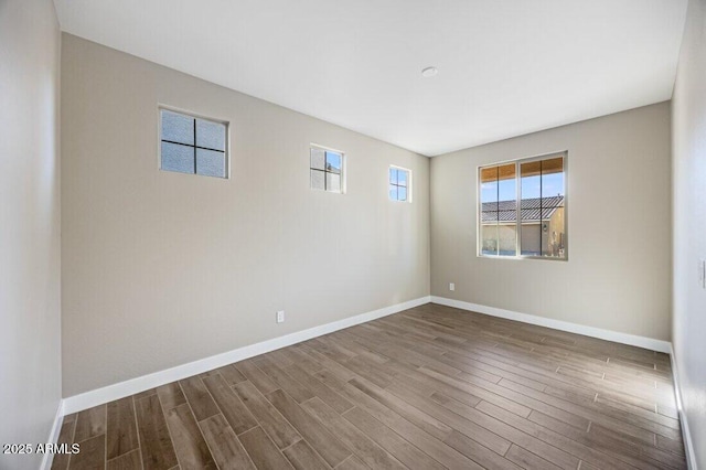 empty room featuring baseboards and wood finished floors