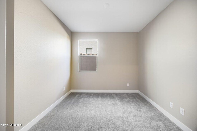 carpeted spare room featuring baseboards