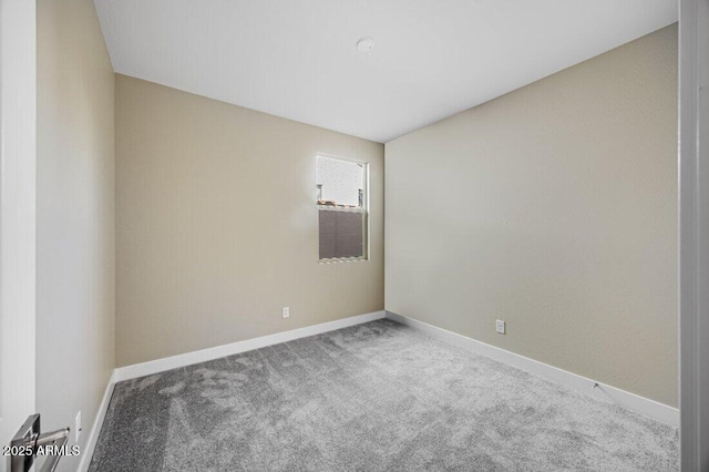 carpeted spare room featuring baseboards