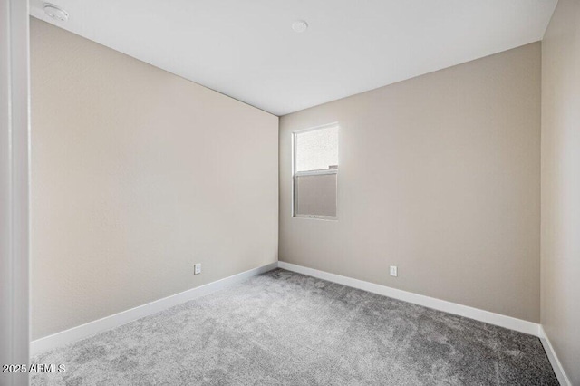 carpeted spare room featuring baseboards