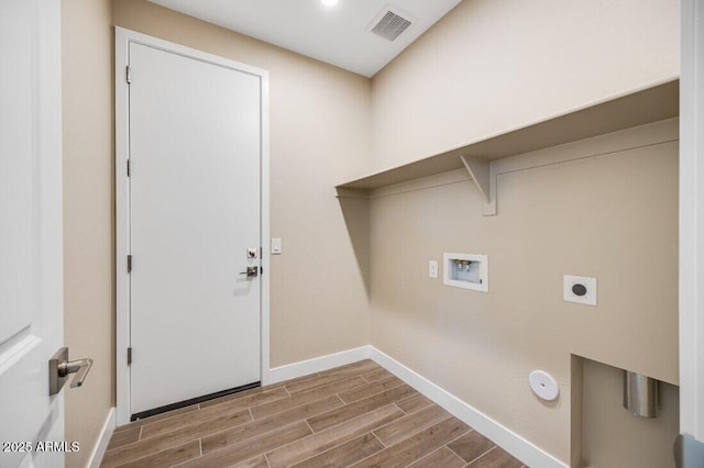 clothes washing area with laundry area, visible vents, wood tiled floor, washer hookup, and electric dryer hookup