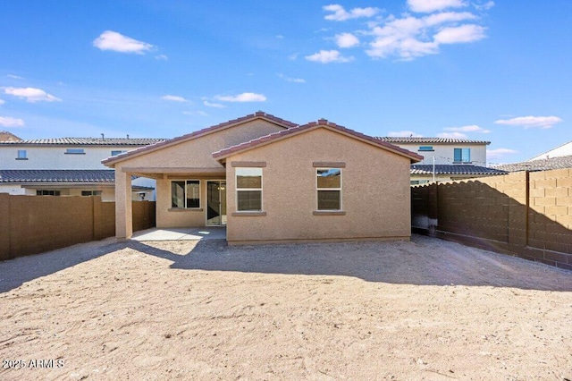 back of property with a patio area, a fenced backyard, a tiled roof, and stucco siding