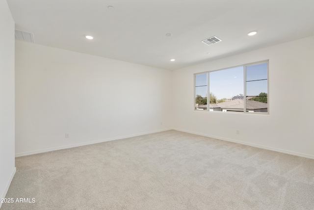unfurnished room featuring light colored carpet, visible vents, baseboards, and recessed lighting