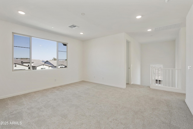 empty room with carpet, visible vents, and recessed lighting