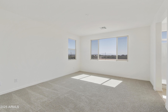 carpeted spare room with baseboards and visible vents