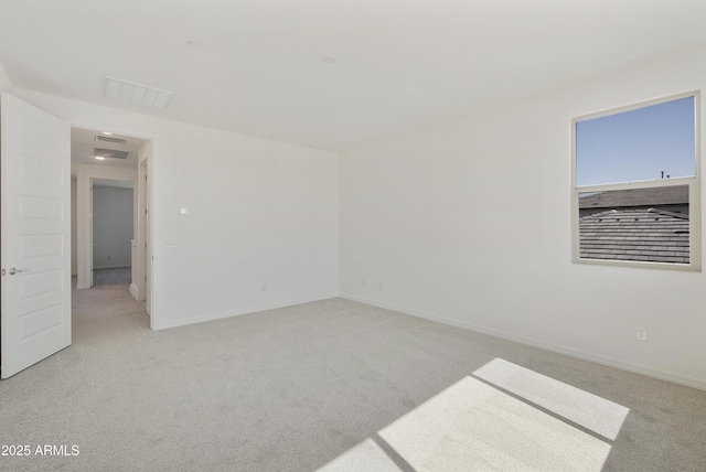 empty room with light carpet, visible vents, and baseboards