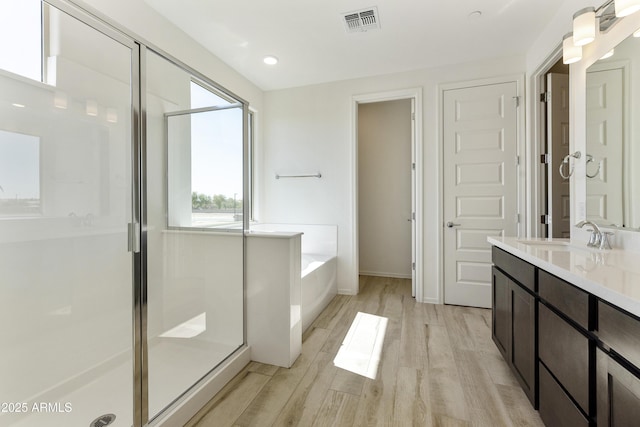 full bath featuring wood finished floors, visible vents, a shower stall, and a bath