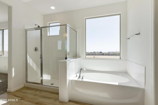 full bathroom featuring a stall shower, a garden tub, recessed lighting, and wood finished floors