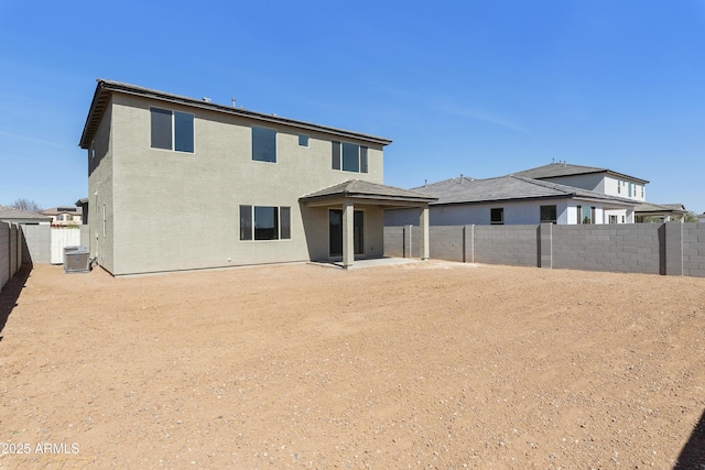 rear view of property with cooling unit, a fenced backyard, a patio, and stucco siding