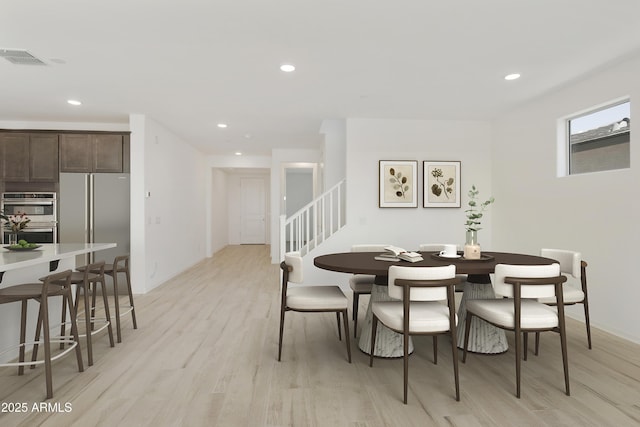 dining space with light wood finished floors, stairs, visible vents, and recessed lighting