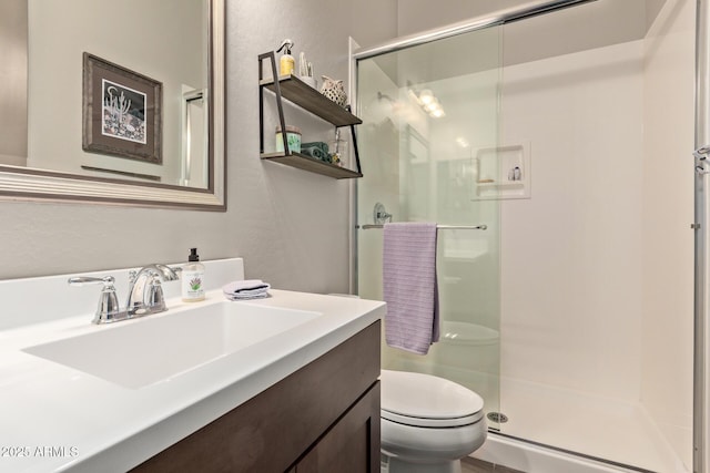 bathroom featuring toilet, walk in shower, and vanity